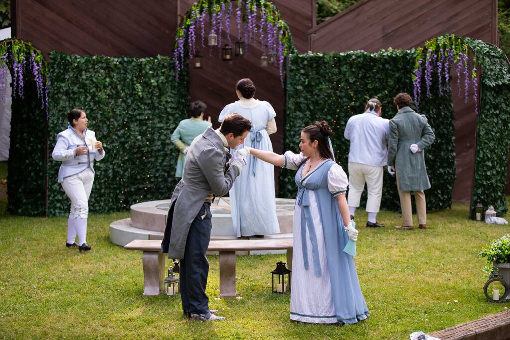 Man kissing a woman's hand. They are standing outside